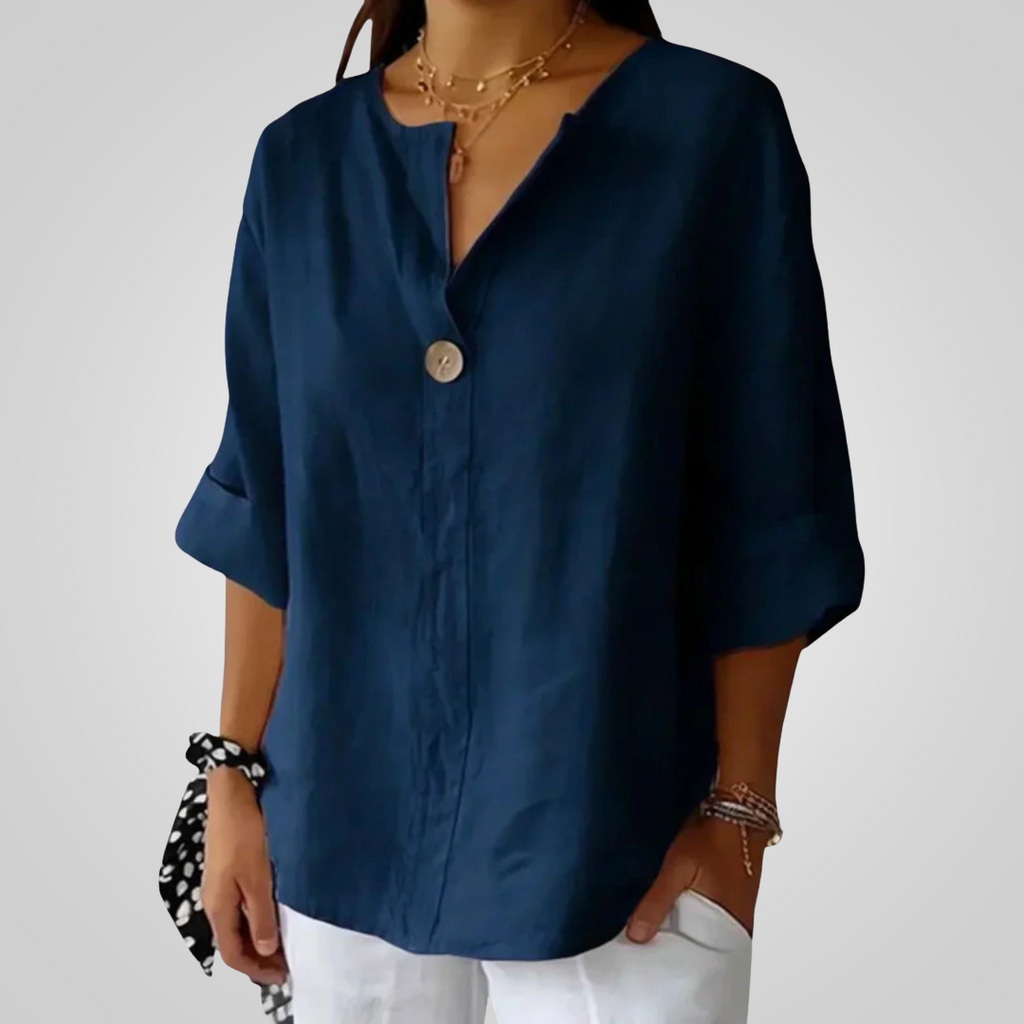 Front view of the Averil Blouse Linen Long-Sleeve in navy blue, featuring a split V-neckline, long rolled sleeves, decorative button detail, and a relaxed linen silhouette. Designed by Bella Hudson.