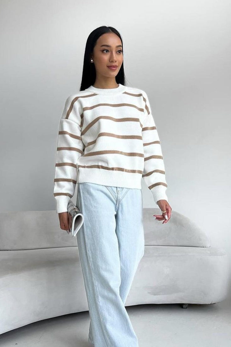 Avery Beige striped crew-neck sweater in white with tan stripes worn with light wash wide-leg jeans.