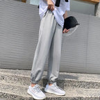Avery Gray high-waisted jogger pants with relaxed legs, adjustable drawstring waistband, side pockets, and elastic ankle cuffs