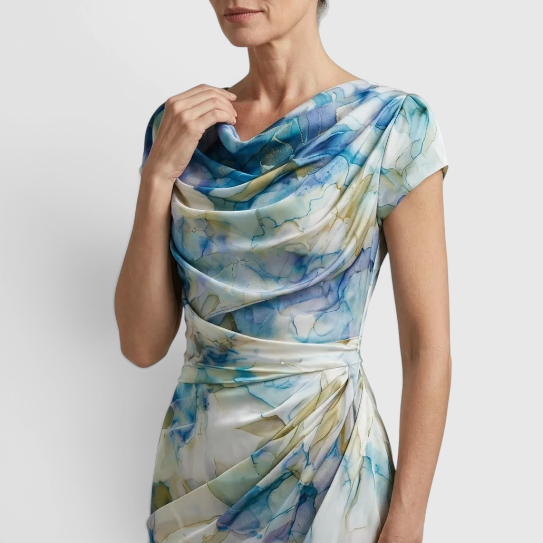 Close-up detail of the Bianca Midi Lightweight Dress Watercolor-Print Cowl-Neck in sky blue, featuring the draped cowl neckline, cap sleeves, lightweight fabric, and watercolor floral print. Designed by Bella Hudson.