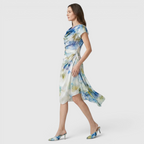 Side view of the Bianca Midi Lightweight Dress Watercolor-Print Cowl-Neck in sky blue, showcasing the draped cowl neckline, cap sleeves, flowing asymmetrical hem, and soft watercolor print. Designed by Bella Hudson.