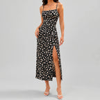 Front view of black floral slit maxi dress with spaghetti straps and fitted silhouette by BELLA HUDSON