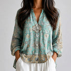 Close-up front view of blue green floral boho lightweight blouse with button front, chest pockets, and long sleeves BELLA HUDSON.