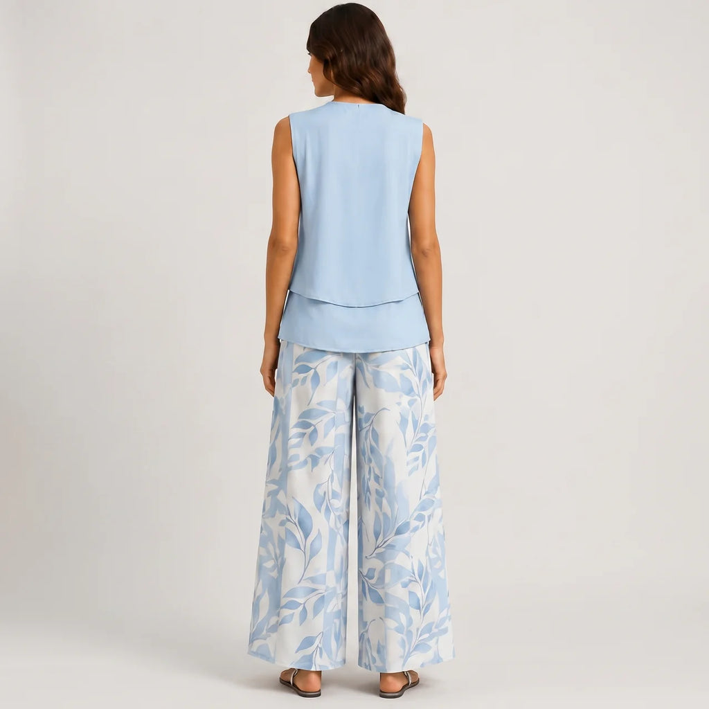 Back view of blue layered sleeveless top and wide leg pants set with floral print by BELLA HUDSON