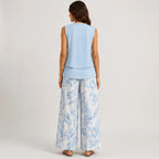 Back view of blue layered sleeveless top and wide leg pants set with floral print by BELLA HUDSON