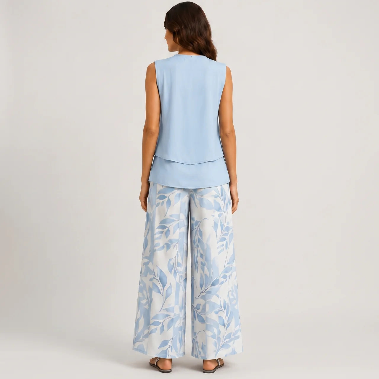 Back view of blue layered sleeveless top and wide leg pants set with floral print by BELLA HUDSON