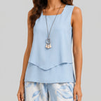 Close-up view of blue layered sleeveless top and wide leg pants set with floral print by BELLA HUDSON