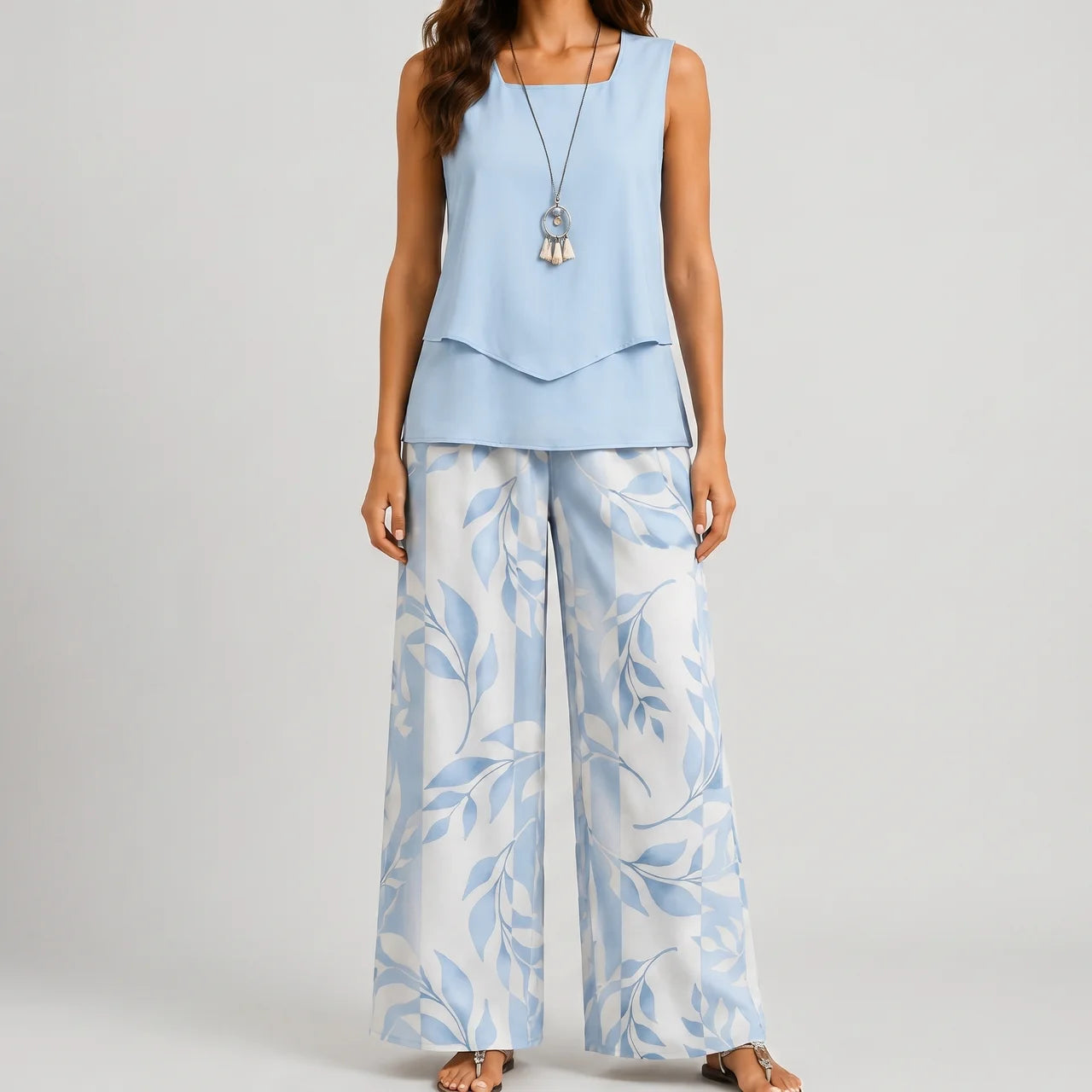 Front view of blue layered sleeveless top and wide leg pants set with floral print by BELLA HUDSON