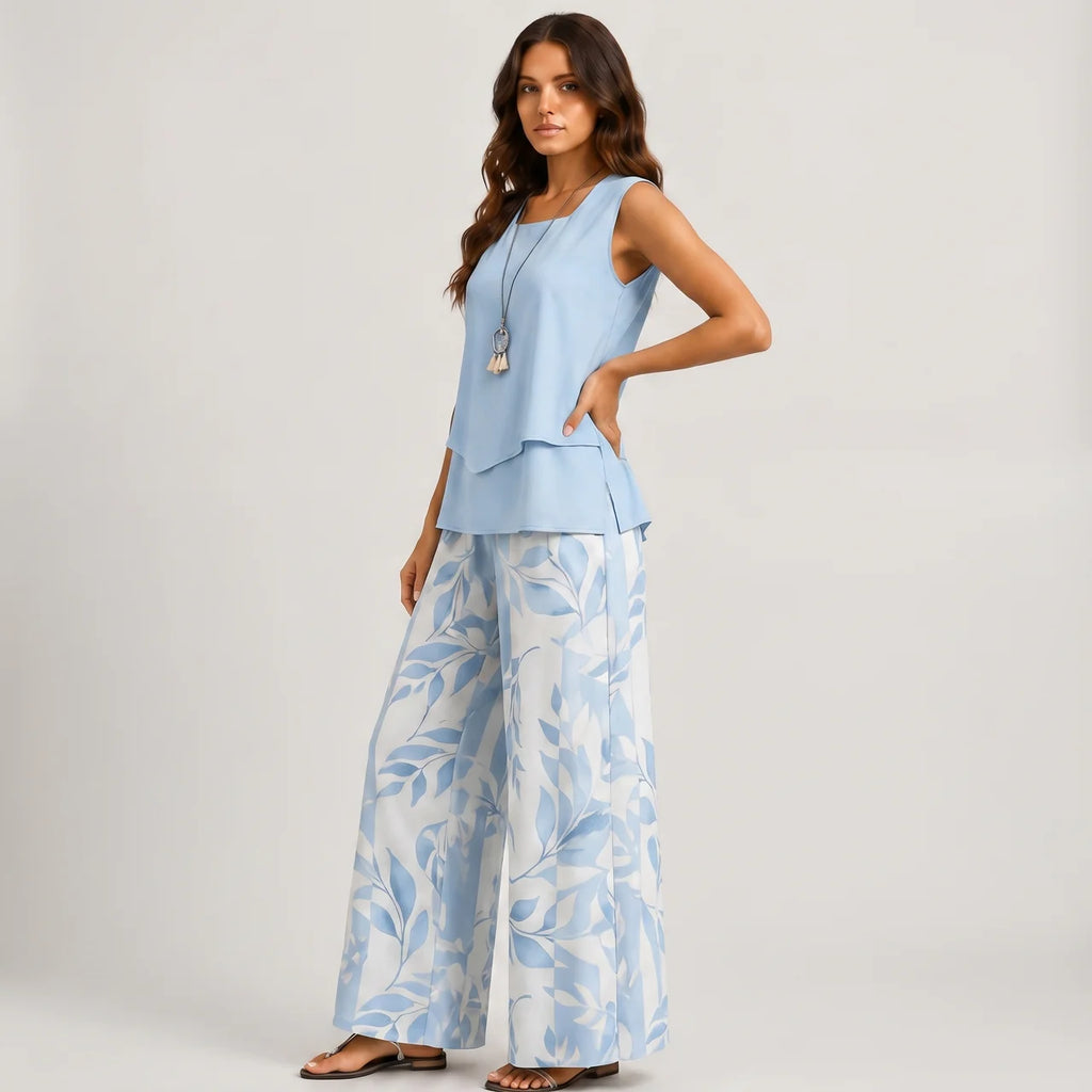 Side view of blue layered sleeveless top and wide leg pants set with floral print by BELLA HUDSON