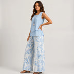 Side view of blue layered sleeveless top and wide leg pants set with floral print by BELLA HUDSON