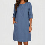 Front view of blue linen midi dress with rolled sleeves and side pockets by BELLA HUDSON