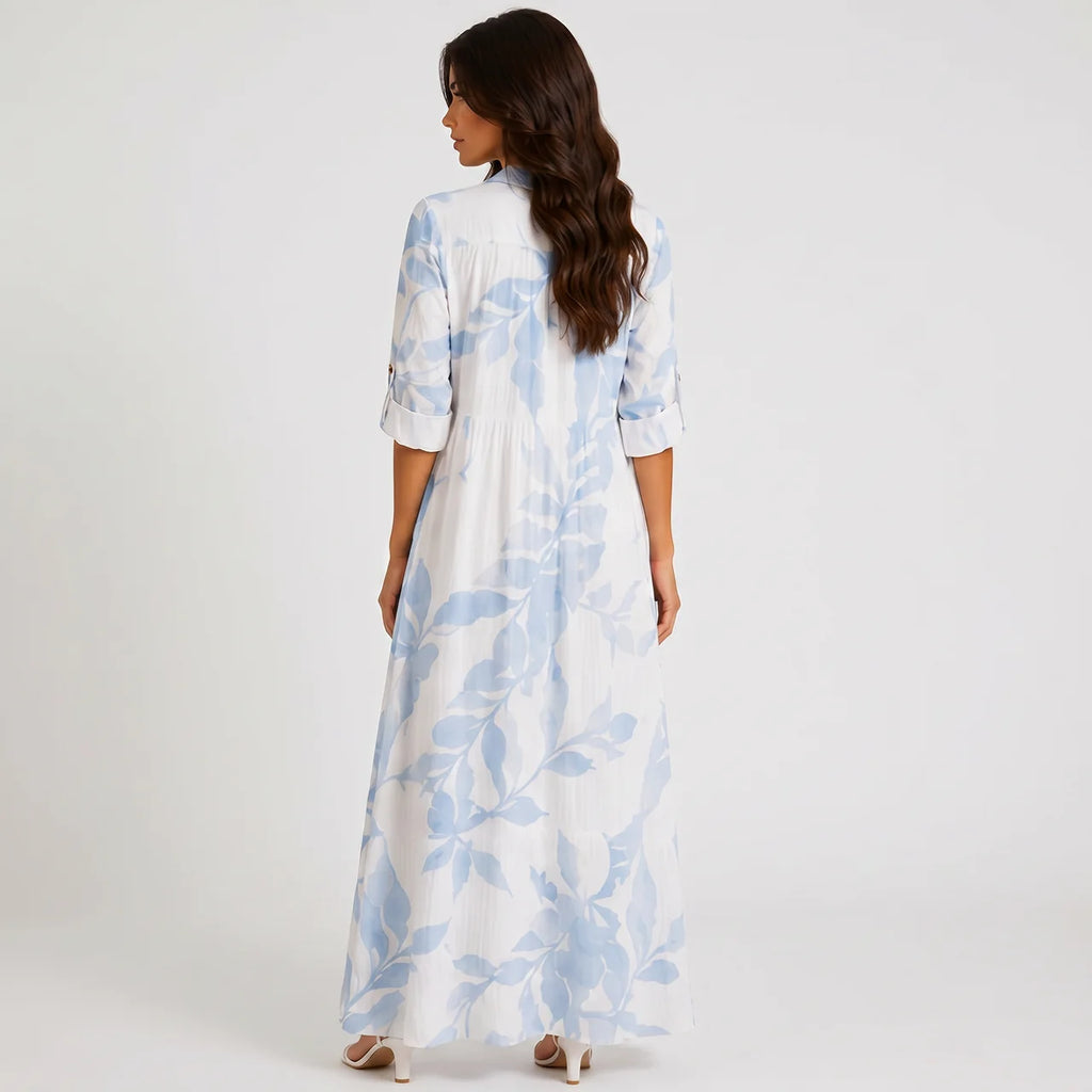 Back view of blue and white tropical print maxi dress with long sleeves by BELLA HUDSON