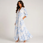 Side view of blue and white tropical print maxi dress with flowing silhouette by BELLA HUDSON