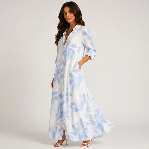 Side view of blue and white tropical print maxi dress with flowing silhouette by BELLA HUDSON