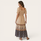 Back view of the Briar Smocked Dress Bohemian Puff-Sleeve Tiered in yellow, highlighting the fully smocked bodice, puff sleeves, and flowing tiered maxi skirt. Designed by Bella Hudson.