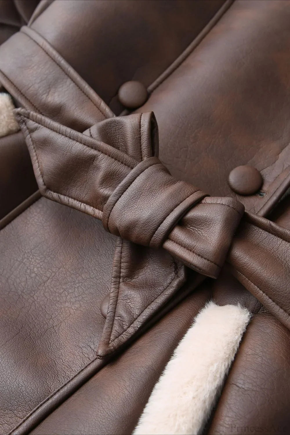 Brielle Brown faux leather jacket close-up of the tied waist belt, covered buttons, and cream faux shearling trim.