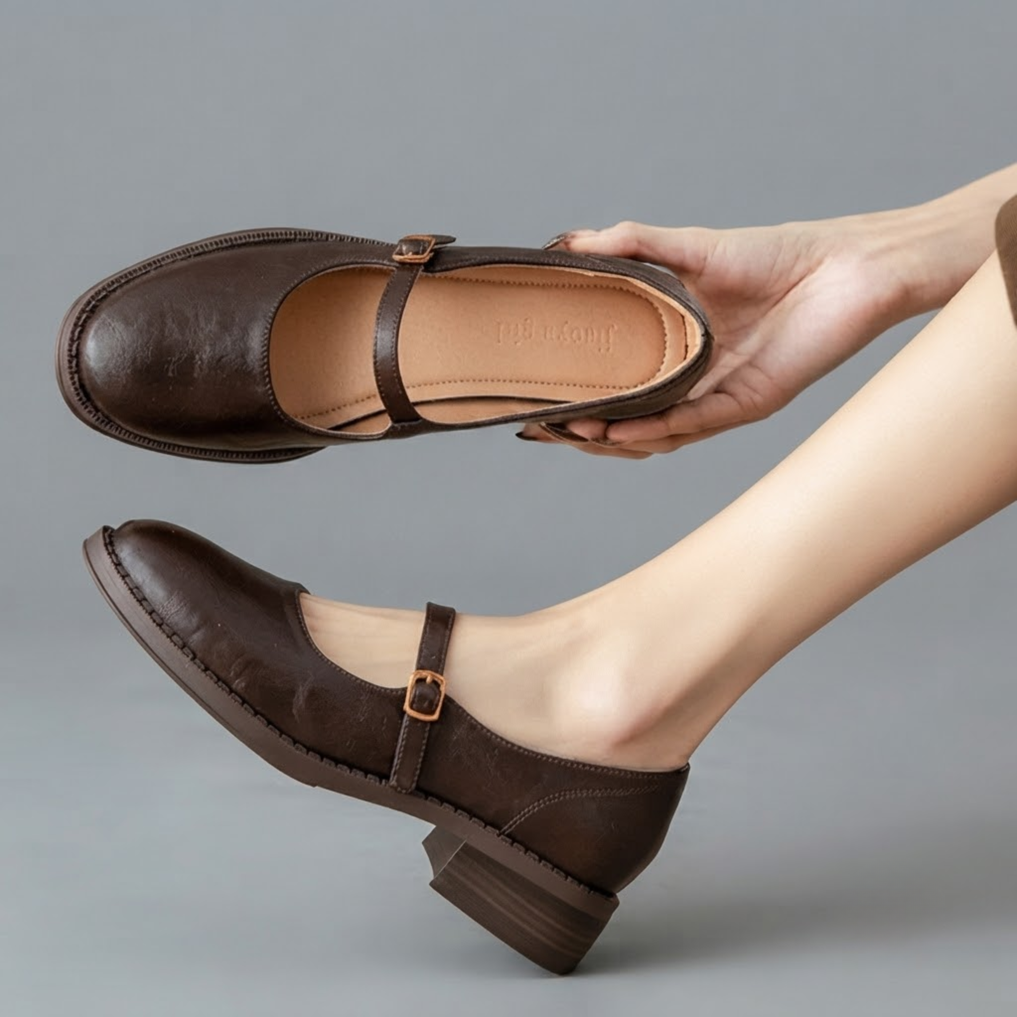 Britt Mary-Jane Flats Block-Heel in Brown displayed in an angled view, highlighting the elegant buckle strap, low block heel, closed-toe design, and versatile everyday style, designed by Bella Hudson