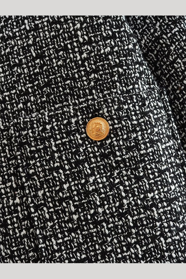 Cadence Grey tweed fabric close-up showing the textured weave and an engraved gold button on the pocket.