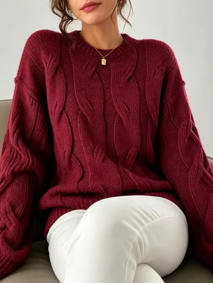 Camila Red cable-knit sweater with crew neckline, braided patterns, and relaxed fit, shown seated