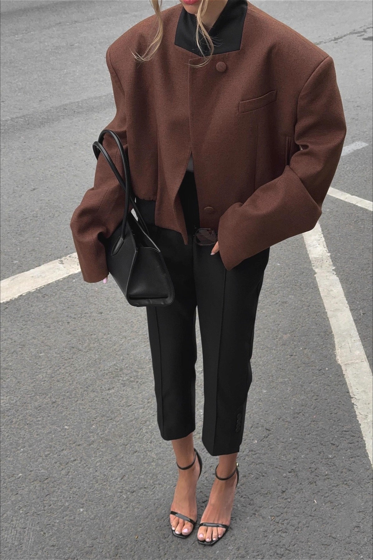 Camille Brown cropped jacket styled from the front with a high collar, asymmetric buttons, and structured silhouette
