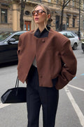 Camille Brown cropped jacket shown from the front with a high collar, structured shoulders, asymmetric button front, and long sleeves