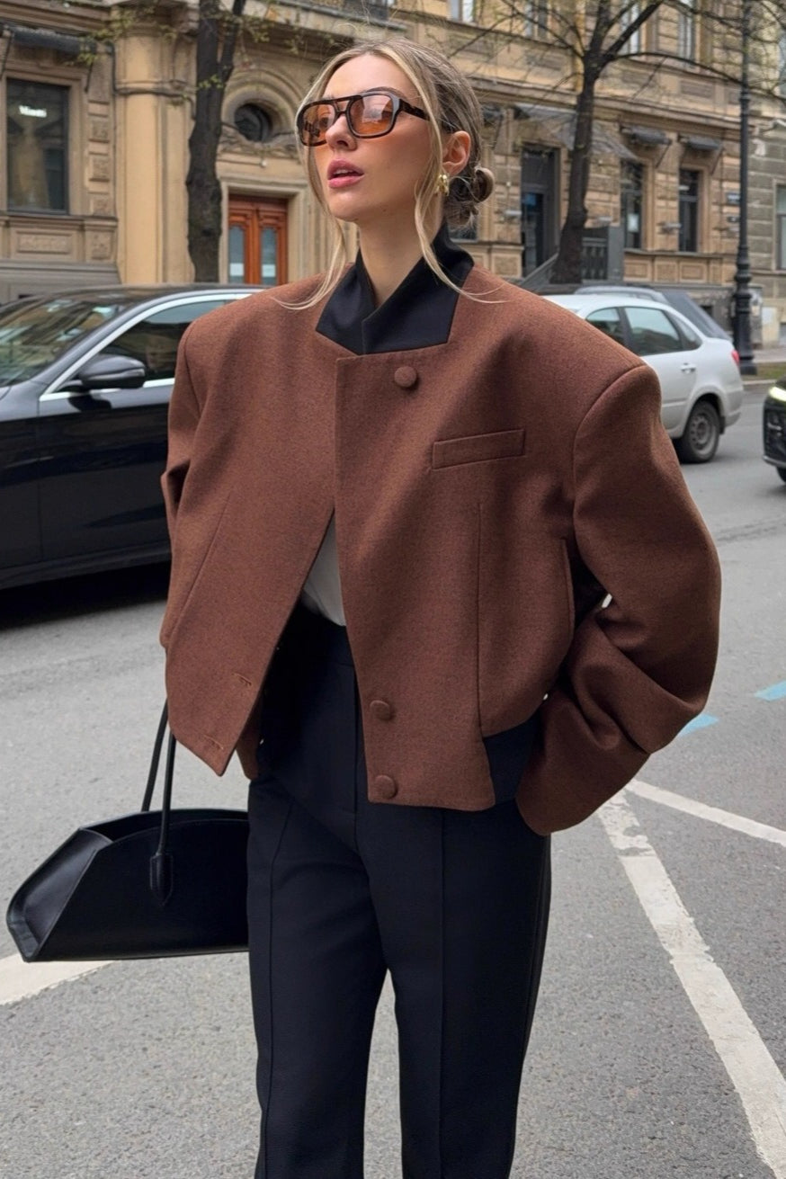 Camille Brown cropped jacket shown from the front with a high collar, structured shoulders, asymmetric button front, and long sleeves