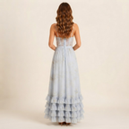Back view of the Camille Maxi Dress Floral-Print Ruffle Side-Slit in Blue, showcasing the flowing maxi length and flattering fit. Designed by Bella Hudson.