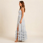 Left side view of the Camille Maxi Dress Floral-Print Ruffle Side-Slit in Blue, highlighting the graceful side slit and flowing silhouette. Designed by Bella Hudson.