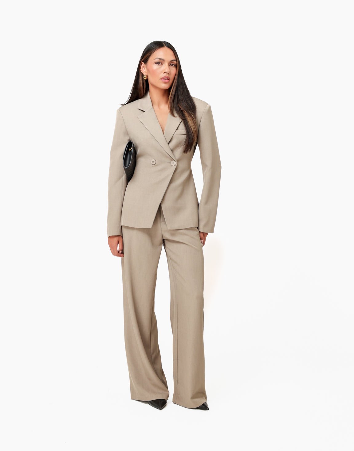 Camille Taupe blazer styled full-body with matching wide-leg trousers and a black clutch.