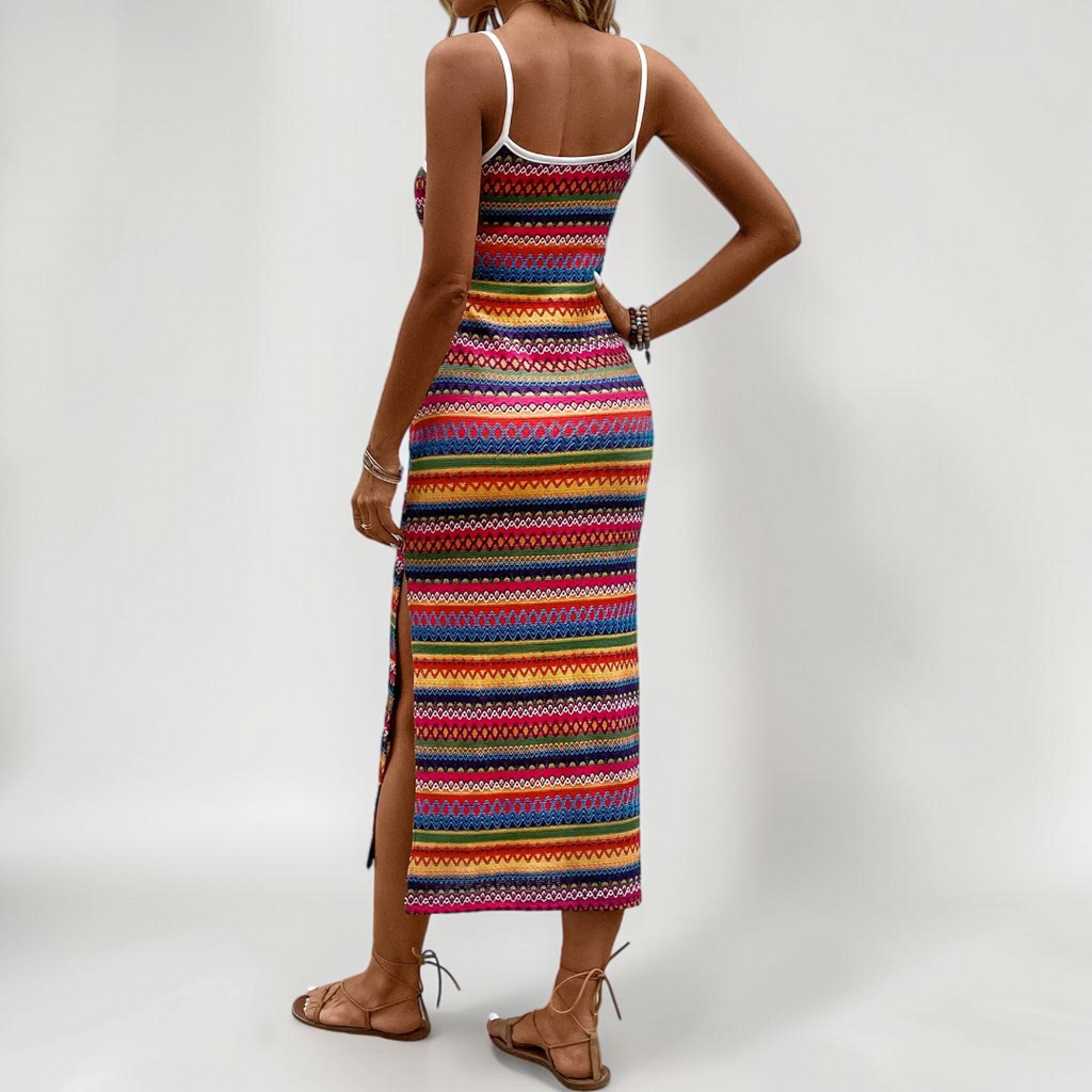 Lifestyle back view of the Cassia Maxi Dress Knit Striped Cami Side-Slit in pink, highlighting the colorful striped knit pattern, sleeveless silhouette, and flowing maxi length. Designed by Bella Hudson.