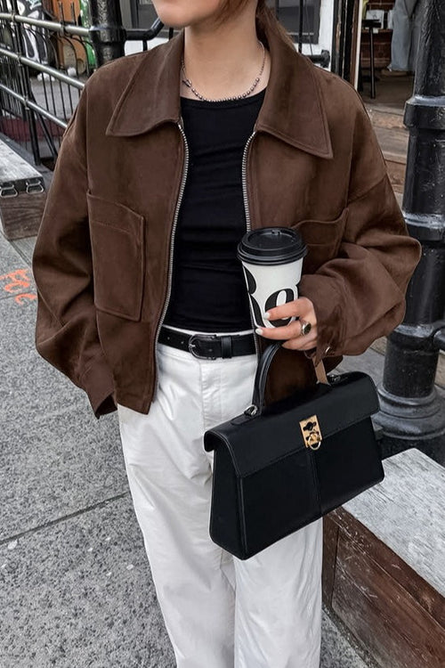 Celine Brown faux suede utility jacket worn open over a black tee with white pants and a black handbag.