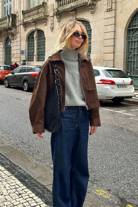 Celine Brown faux suede utility jacket worn zipped over a gray turtleneck with dark wide-leg jeans on the street.