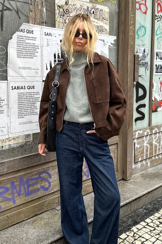 Celine Brown faux suede utility jacket styled with a gray knit and wide-leg dark jeans in a full-length look.