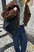 Celine Brown faux suede utility jacket styled with a gray turtleneck, dark jeans and a woven black bag, showing the snap cuff.