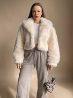 Charlotte Beige cropped faux-fur jacket with a wide lapel collar, oversized long sleeves, open front, and plush textured finish