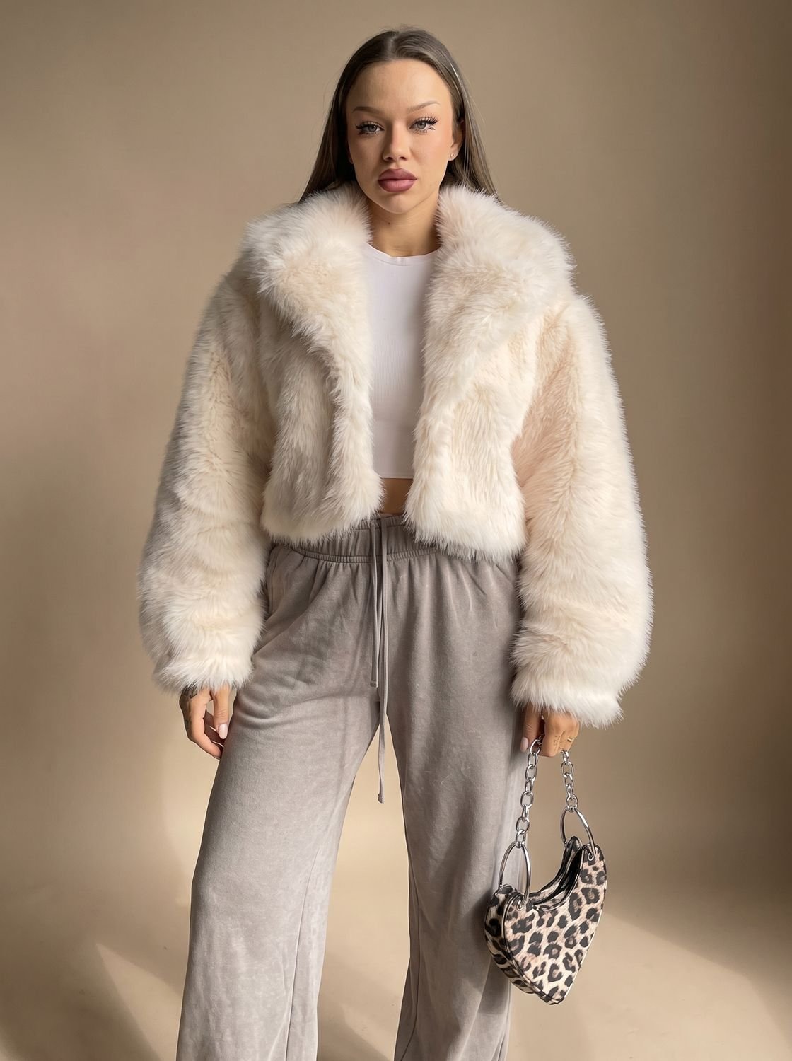 Charlotte Beige cropped faux-fur jacket with a wide lapel collar, oversized long sleeves, open front, and plush textured finish
