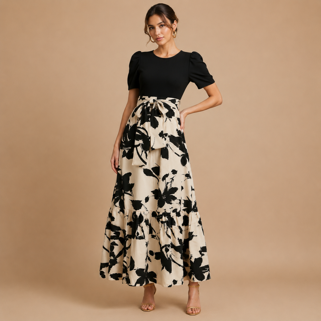 Side view of the Claire Bow-Tie Maxi Dress featuring a bow-tie waist detail and cream floral print skirt. Designed by Bella Hudson.