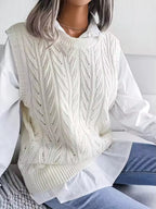 Claire White cable-knit sweater vest with decorative openwork, crew neckline, and ribbed hem, shown seated