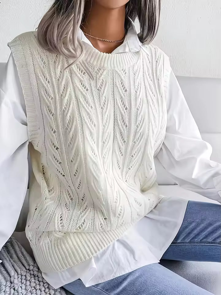 Claire White cable-knit sweater vest with decorative openwork, crew neckline, and ribbed hem, shown seated