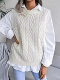 Claire White cable-knit sweater vest with crew neckline, openwork detailing, and ribbed hem, layered over a collared shirt