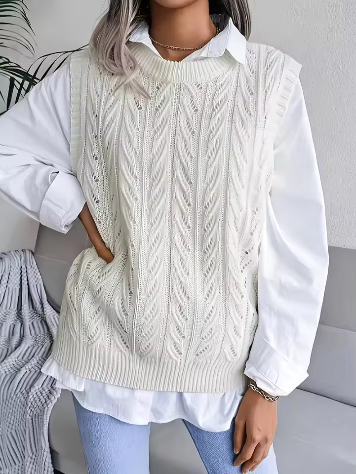 Claire White cable-knit sweater vest with crew neckline, openwork detailing, and ribbed hem, layered over a collared shirt