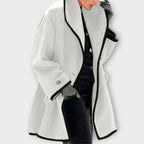 Claire White contrast-trim coat with a wide shawl collar, oversized fit, long sleeves, and a flowing open-front design