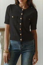 Clara Black short-sleeve knit cardigan shown in a full-body view with a fitted shape, ribbed trim, and front pockets