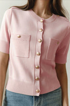 Clara Pink knit cardigan close-up showing gold buttons, ribbed cuffs, and patch pockets.