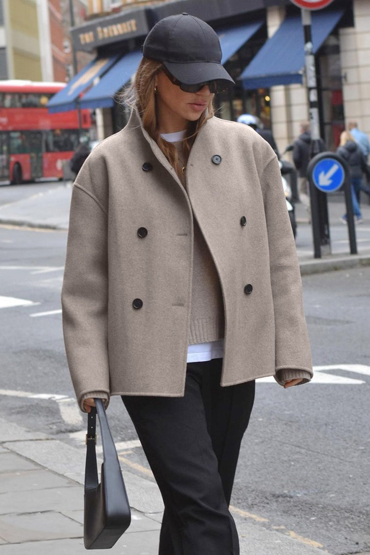 Clara Taupe double-breasted jacket shown in a full-body view with a high stand collar, relaxed silhouette, and long sleeves