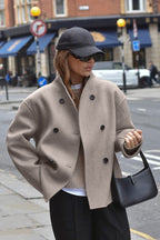 Clara Taupe stand-collar jacket in a relaxed front view highlighting the double-breasted buttons and dropped shoulders
