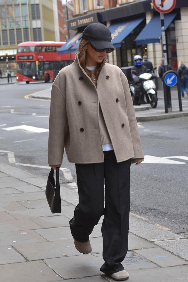 Clara Taupe double-breasted stand-collar jacket styled outdoors with a short length and relaxed silhouette