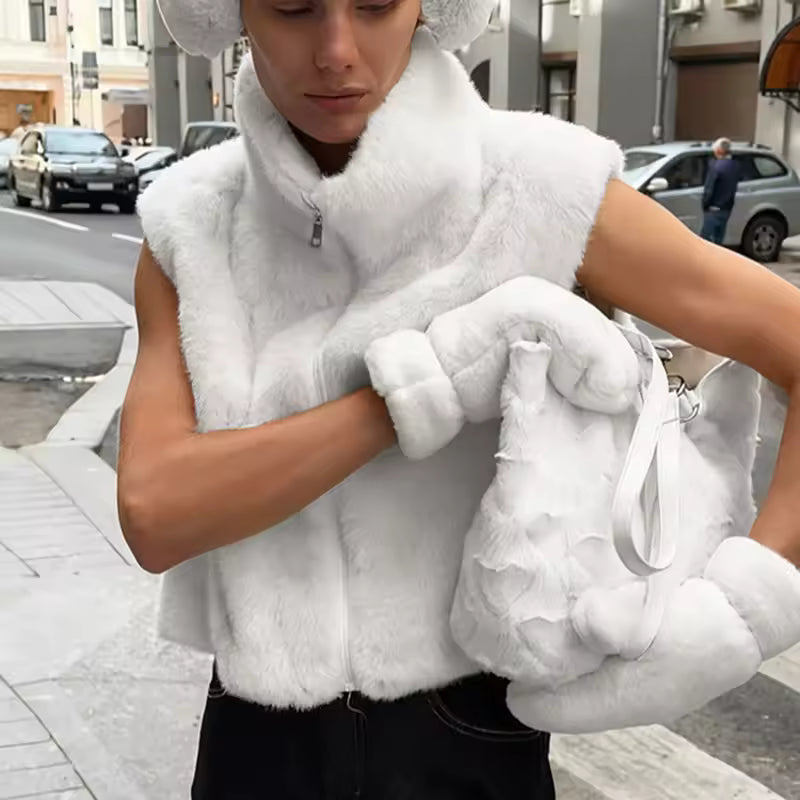 Clara White faux-fur zip vest with high stand collar, sleeveless silhouette, full front zipper, and plush textured finish