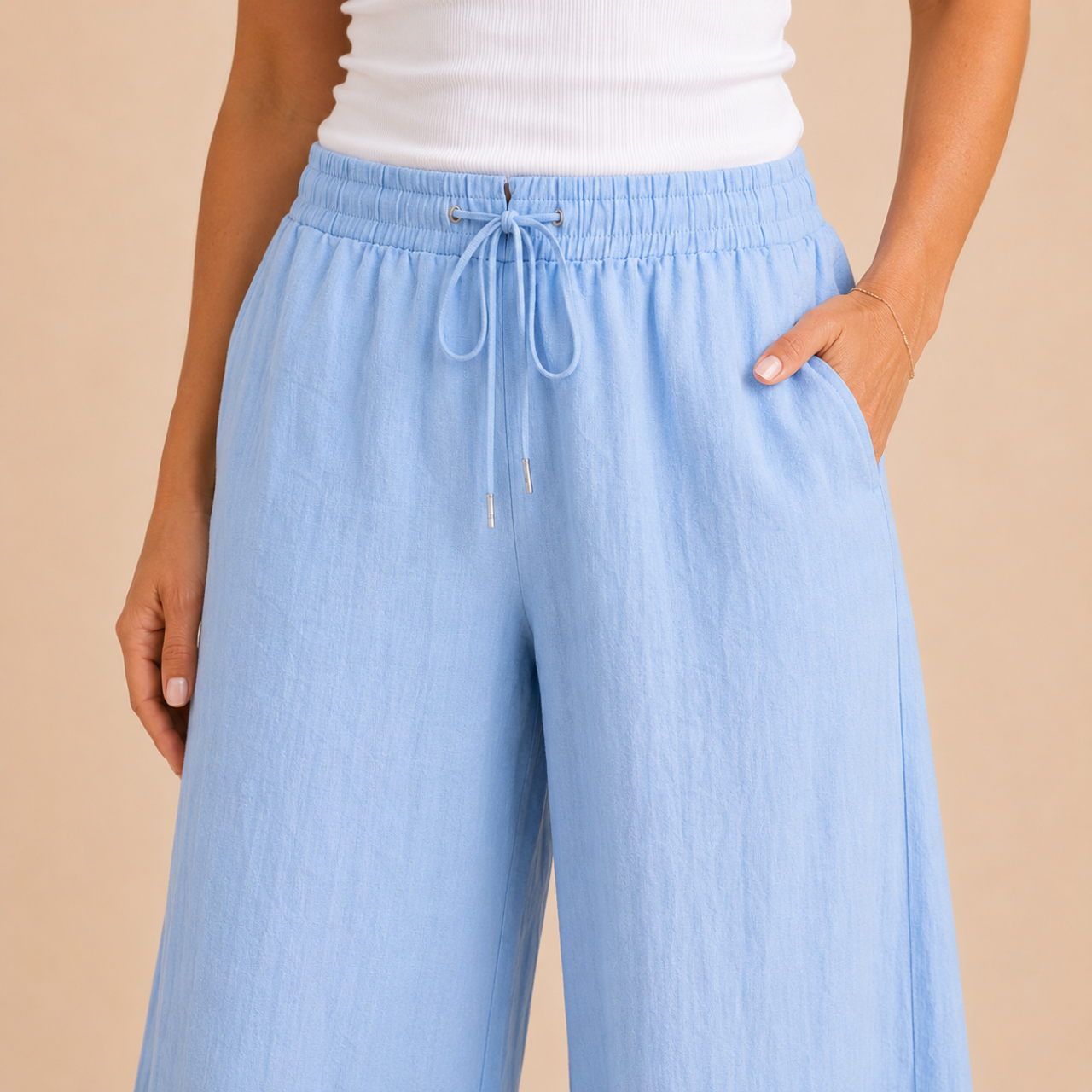 Close-up view of the Cleo Lightweight Linen Wide-Leg Summer Pants in blue, highlighting the lightweight linen fabric, elastic waistband, and drawstring detail. Designed by Bella Hudson.