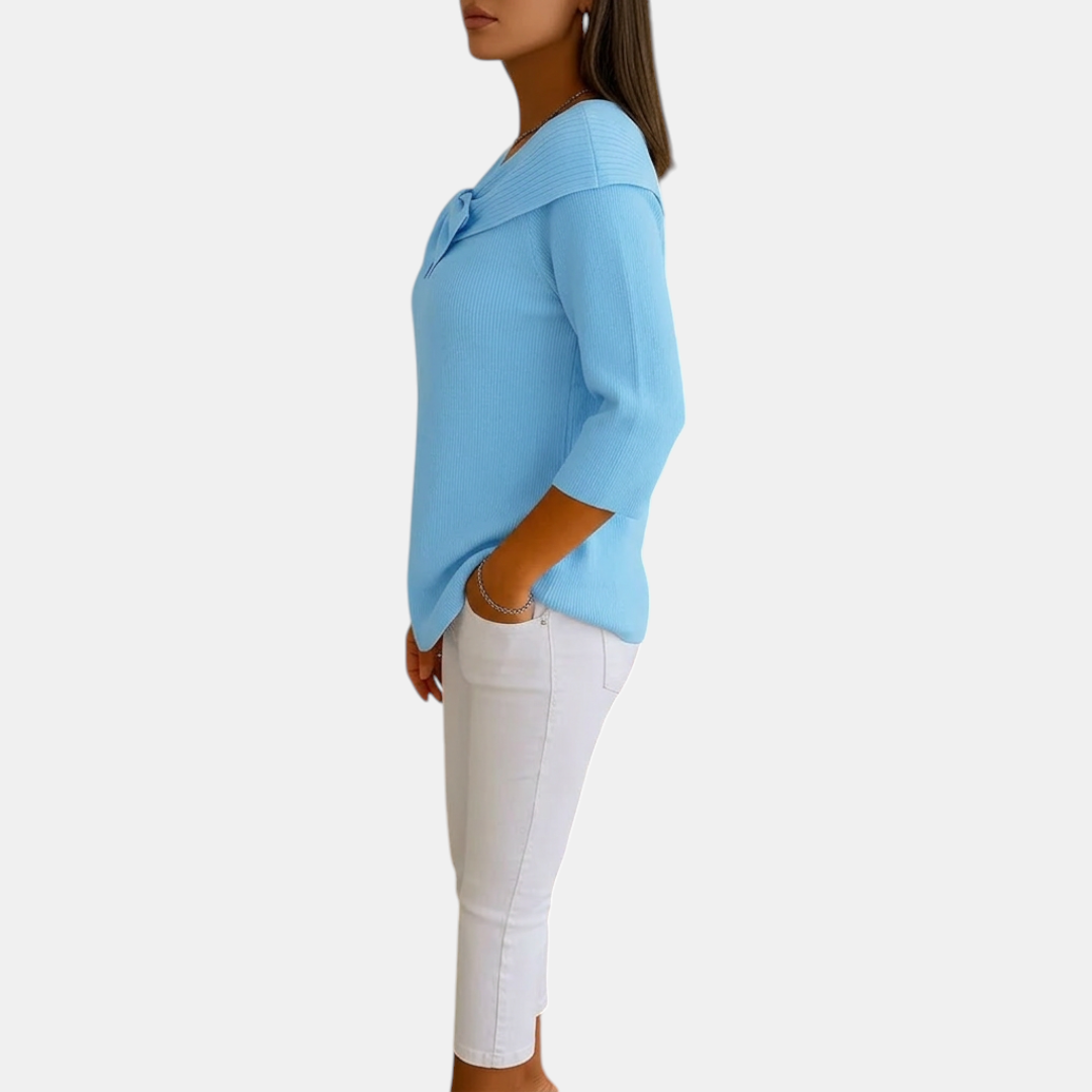 Side view of the Colette Bow-Tie Long Sleeve T-shirt in blue, highlighting the relaxed fit, curved hem, ribbed fabric, and elegant bow neckline. Designed by Bella Hudson.